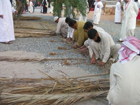 men tying palm leaves together