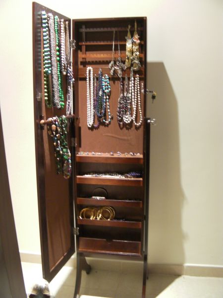 a free standing full length mirror with a  jewelry storage area inside